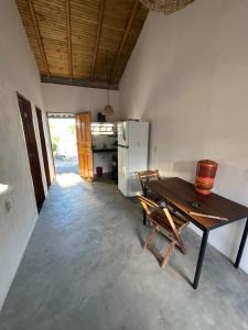 a table and chairs in a room with a refrigerator at Casa Mojubá in Porto Seguro