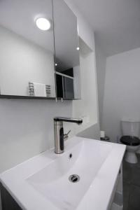 a white bathroom with a sink and a mirror at Lovat Hotel in Perth