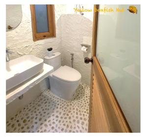 a bathroom with a white toilet and a sink at Yellow Boxfish Hut in Ban Thong Phlu