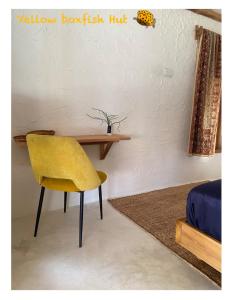 a yellow chair and a table in a room at Yellow Boxfish Hut in Ban Thong Phlu