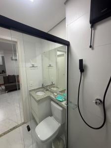 a bathroom with a toilet and a sink at Apartamento Loretto in Espirito Santo Do Pinhal +11 photos