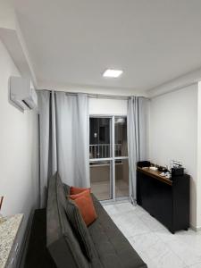 a living room with a couch and a desk at Apartamento Loretto in Espirito Santo Do Pinhal