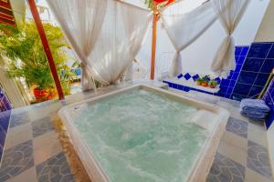 a jacuzzi tub in a bathroom with blue tiles at Selva María Hotel Boutique in Santa Fe de Antioquia
