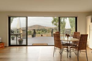 a dining room with a table and chairs and a balcony at An Unforgettable View in Dixons Creek