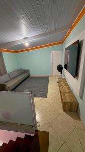 a living room with a couch and a tv at Casa praia e piscina in Bertioga