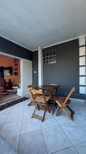 a wooden table and chairs in a room with a table at Casa praia e piscina in Bertioga