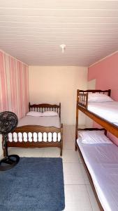 a room with two bunk beds and a blue rug at Casa praia e piscina in Bertioga