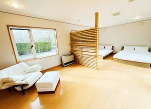 a living room with two beds and a couch at Yunokawa Onsen KOMOREBISO in Hakodate +52 photos
