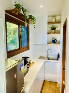 a kitchen with white cabinets and a sink and a window at Casa Yvanna in Alfonso