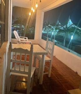 a dining room table and chairs with a view of a stadium at Acogedora recámara, con balcón y entrada independiente in Tampico