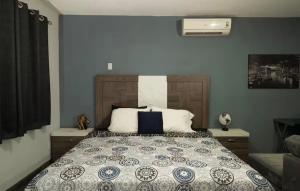 a bedroom with a large bed with blue walls at Acogedora recámara, con balcón y entrada independiente in Tampico