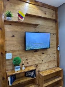 a flat screen tv on a wooden wall at Gold Stay Residence 2 in Belo Horizonte