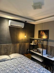 a bedroom with a bed and a desk with a air conditioner at Gold Stay Residence 2 in Belo Horizonte