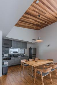 a large kitchen with a wooden table and chairs at Myoko Cedric Villa 01 in Myoko
