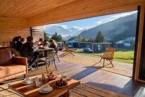 a group of people sitting at a table on a deck at Puerta austral in Puelo