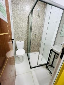 a bathroom with a toilet and a glass shower at Hostel Cünhatã in Belém