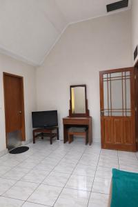 a living room with a television and a mirror at Villa Argapuri Hills in Ciwidey
