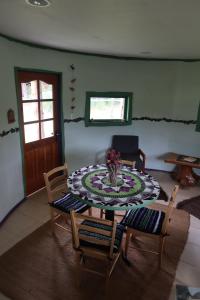 a living room with a table and chairs and a door at Cabaña Casa Morada in Futaleufú