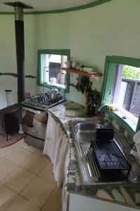 a kitchen with a sink and a stove at Cabaña Casa Morada in Futaleufú +32 photos