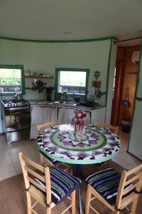 a kitchen with a table and two chairs and a kitchen with a counter at Cabaña Casa Morada in Futaleufú