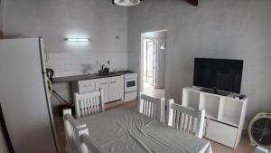 a kitchen with a table and chairs and a television at Departamento Escobar in Belén de Escobar