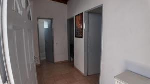 a hallway with white walls and a door to a room at Departamento Escobar in Belén de Escobar
