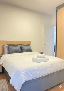a bedroom with a large white bed with towels on it at Refugio do Sol in Extrema