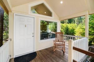 a small porch with a white door and a chair at New Tiny Home Steps Away From Mt. Rainier in Ashford