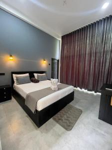 a bedroom with a bed with a teddy bear on it at Sinharaja Eliphinity Hotel and Restaurant in Deniyaya