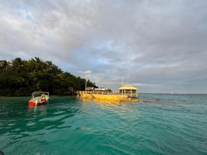 a boat in the water next to a dock in the water at Bokanbotin Island Resort in Majuro