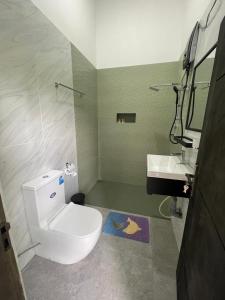 a bathroom with a white toilet and a sink at Sinharaja Eliphinity Hotel and Restaurant in Deniyaya +102 photos