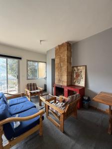 a living room with a blue couch and a fireplace at Faraya chalet in Fārayyā