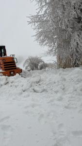 a pile of snow with a bulldozer in the background at Faraya chalet in Fārayyā +1 photo
