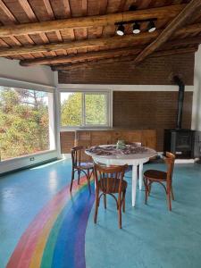 a room with a table with chairs and a rainbow rug at Villa Pellegrini in Trapiche