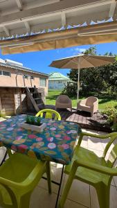 a table and chairs with an umbrella on a patio at Bungalow Marie in Saint-François