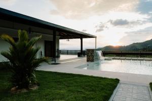 a house with a swimming pool next to a building at Hotel Catleya Royal Club in Pereira