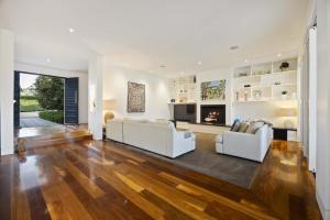 a living room with two white couches and a fireplace at Edgewater in Balnarring Beach