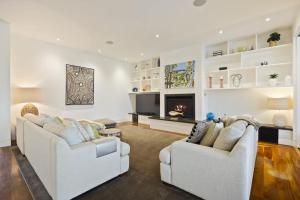 a living room with two white couches and a fireplace at Edgewater in Balnarring Beach +32 photos
