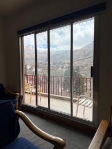 a room with a large window with a view of the mountains at Faraya square chalet in Fārayyā