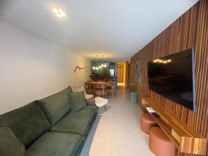 a living room with a green couch and a television at Diamantino Residence - apt 07 CalmariaMucuge in Mucugê