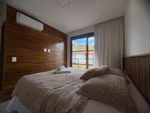 a bedroom with a large bed with a window at Diamantino Residence - apt 07 CalmariaMucuge in Mucugê +29 photos