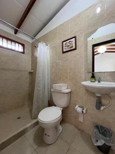 a bathroom with a toilet and a sink at Lago Calima Hostel in Calima