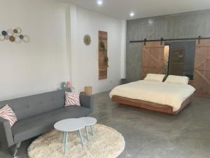 a bedroom with a bed and a couch and a table at Studio Thakhek-private loft with terasse in Thakhek