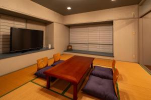 a room with a table and chairs and a flat screen tv at セト ヴィスタ 牛窓 in Setouchi