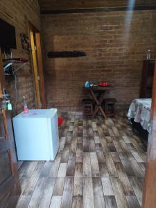 a room with a white refrigerator and a table at Chalés Beira Rio in Santo Antônio do Pinhal
