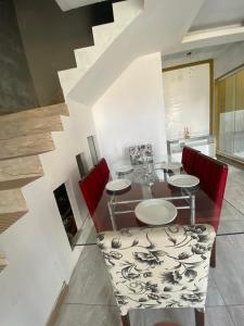 a dining room with a table and red chairs at Suíte por do sol 2 casa compartilhada in Xangri-lá
