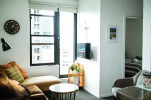 a living room with a couch and a clock on the wall at Top Floor - Secure Parking - Great Location - Quiet - City Ciew in Wellington +28 photos