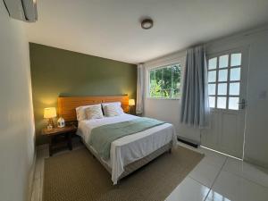 a bedroom with a large bed and a window at Sítio Mais Lindo do Mundo in Ilha de Guaratiba