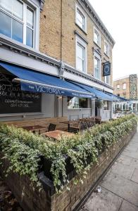 a restaurant with blue umbrellas in front of a building at Victoria Inn in London