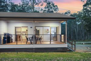 a house with a screened in porch with a deck at 27 Rows on Hermitage in Pokolbin